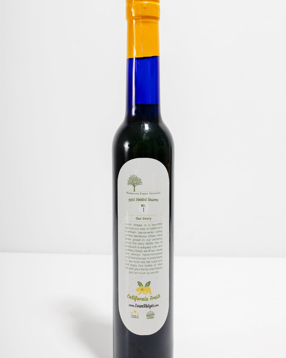 Loam Ridges Barceloux Family Orchards extra virgin olive oil back label showing California-grown Sevillano olive orchard story – made in America small batch EVOO