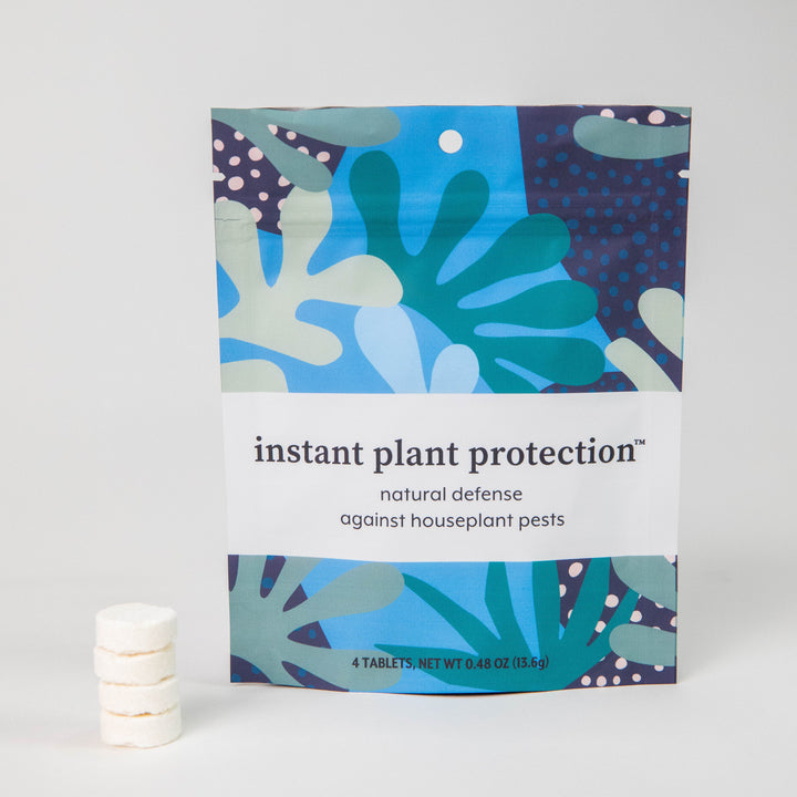 Instant Plant Protection 4-tablet pouch standing upright next to a stacked column of white pest control tablets on a plain background